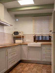 a kitchen with white cabinets and a sink at El Trastero Suite in Montellano
