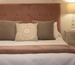 a bed with a large headboard and pillows at El Trastero Suite in Montellano +14 photos