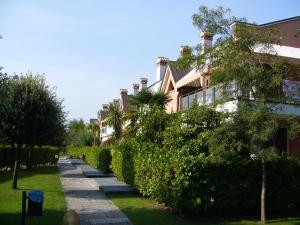 a sidewalk in front of a house with bushes at Residence Nuovo Sile in Cavallino-Treporti