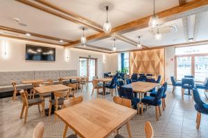 a dining room with wooden tables and chairs at Dom pod Tęczą in Ludźmierz