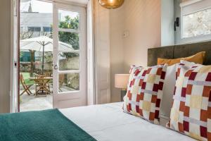 a bedroom with a bed and a table with an umbrella at Almada Charm Suites & Apartments in Porto