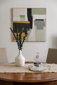 a white vase with flowers in it on a table at Almada Charm Suites & Apartments in Porto