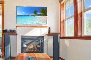 a living room with a fireplace and a picture of the beach at Luxury condo with stunning views! in Fraser