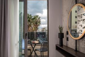 eine Tür zu einem Balkon mit einem Tisch und einem Spiegel in der Unterkunft CITY NEST Living in Iraklio