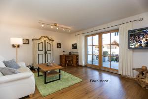 a living room with a white couch and a table at Ferienwohnung Mitteldorf in Oberammergau