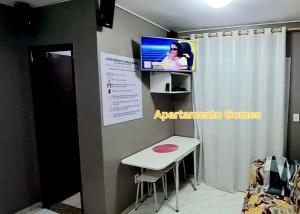 a room with a table and a tv on a wall at Apartamento Gomes Wi-Fi Aviação P Grande in Praia Grande