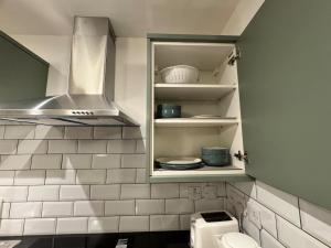 a kitchen with a cupboard with dishes on it at Town centre 1 Cozy king size bed ensuit shower in Huntingdon +12 photos