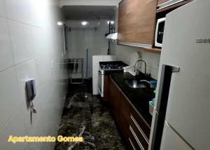 a small kitchen with a sink and a stove at Apartamento Gomes Wi-Fi Aviação P Grande in Praia Grande +18 photos