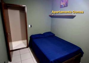 a small bedroom with a blue bed in a room at Apartamento Gomes Wi-Fi Aviação P Grande in Praia Grande