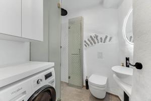 baño blanco con lavadora y lavamanos en Cozy nest in the old town, en Tallin 15 fotos más