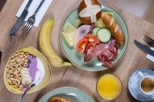 two plates of food on a wooden table with breakfast foods at Garner Hotel Oberhausen by IHG in Oberhausen