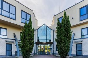 an office building with trees in front of it at Garner Hotel Oberhausen by IHG in Oberhausen