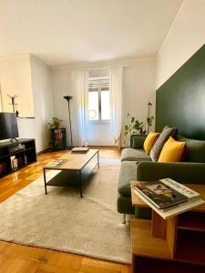 a living room with a green couch and a coffee table at Downtown Milan Chic Apartment - Quiet Retreat with Free WIFI & Air Conditioning in Milan