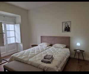 a bedroom with a bed with a towel on it at Casa do Leão II in Évora
