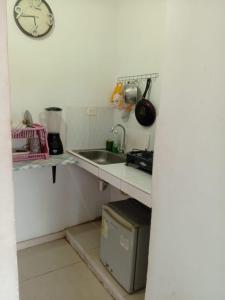 a kitchen with a sink and a clock on the wall at mirador 1 in Santa Marta