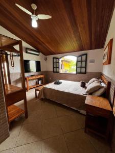 a bedroom with a bed with a wooden ceiling at Casa Três Amores in Búzios +50 photos