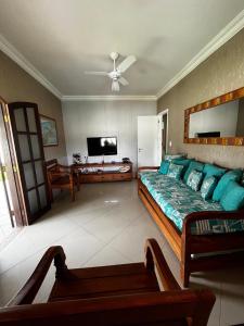 a bedroom with a bed and a flat screen tv at Casa Três Amores in Búzios