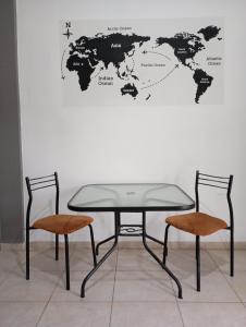 una mesa con dos sillas y un mapa mundial en la pared en Loloh, en Formosa