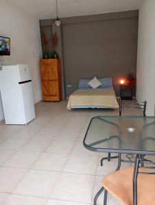 una habitación con una cama, una mesa y un refrigerador en Loloh, en Formosa