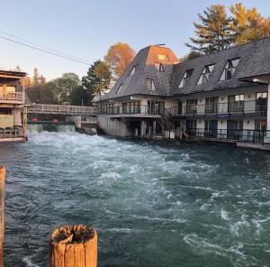 un fiume di fronte a un edificio con rapide d'acqua di The Harbormaster a Suttons Bay
