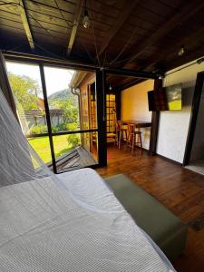 a room with a bed and a dining room with a table at Guarda do Embau Gran Kahuna in Palhoça