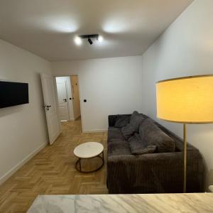 a living room with a couch and a table at Marszałkowska City Center Apartment With Working Space in Rzeszów