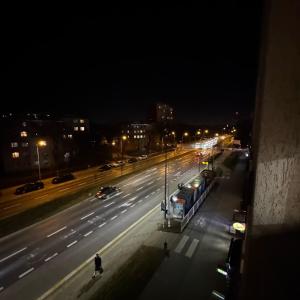 a city street at night with a bus on the road at Marszałkowska City Center Apartment With Working Space in Rzeszów