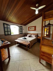 a bedroom with a bed and a ceiling fan at Casa Três Amores in Búzios