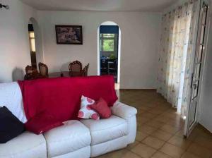 a living room with a white couch with red pillows at KARENGA house type F4 in Sainte-Anne