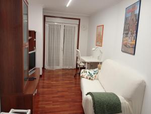 a living room with a white couch and a table at Apartamento Rio Grande in Fisterra