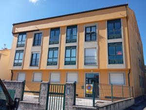 a building with windows and a fence in front of it at Apartamento Rio Grande in Fisterra