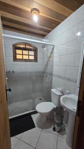 a bathroom with a toilet and a sink at Casa Três Amores in Búzios