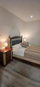 a bedroom with a large bed with two lamps on it at Casa Do Olival - Suítes in São João da Pesqueira