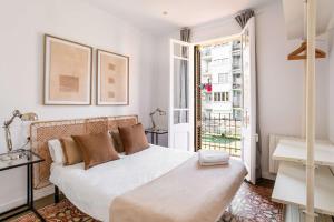 ein Schlafzimmer mit einem großen weißen Bett und einem Fenster in der Unterkunft Sagrada Familia- Emblematic and Charming Catalan Home in Barcelona