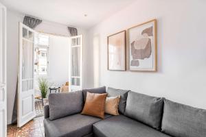 ein Wohnzimmer mit einem grauen Sofa in einem Zimmer in der Unterkunft Sagrada Familia- Emblematic and Charming Catalan Home in Barcelona