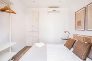 ein weißes Zimmer mit einem Bett und einer Lampe in der Unterkunft Sagrada Familia- Emblematic and Charming Catalan Home in Barcelona + 15 Fotos
