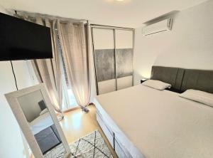 ein Schlafzimmer mit einem Bett und einem großen Fenster in der Unterkunft Beautiful Apartment, Close to Beach in Split