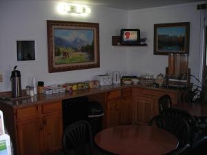 a kitchen with wooden cabinets and a table with chairs at Cozy Inn in Cortez