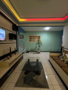 salon z kanapą i telewizorem w obiekcie casa 3 quartos1suíte com frigobar smart tv netflix ar-condicionado w mieście Campina Grande