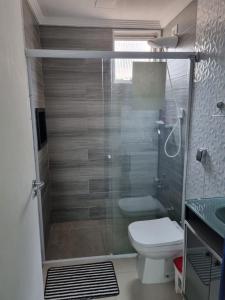 a bathroom with a shower with a toilet and a sink at Apartamento Classe A in Praia Grande +32 photos