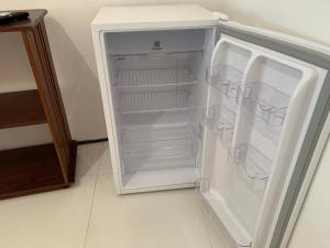 an empty refrigerator with its door open in a kitchen at Chalés de Morro Branco in Beberibe