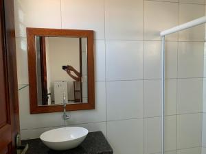 a person taking a picture of a bathroom mirror at Chalés de Morro Branco in Beberibe