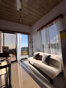 a living room with a couch and a large window at Cabina Hermanas Valencia in Monteverde Costa Rica