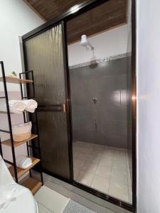 a shower with a glass door in a room at Cabina Hermanas Valencia in Monteverde Costa Rica