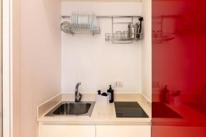 a kitchen with a sink and a red wall at Seaside Apartment Near St Nicholas Basilica in Bari +51 photos