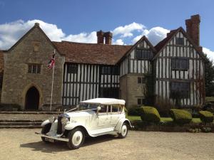 un viejo coche blanco estacionado frente a un edificio en Long Crendon Manor B&B, en Long Crendon