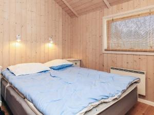 a large bed in a room with wooden walls at 6 person holiday home in Højby-By Traum in Højby