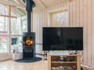 a living room with a television and a fireplace at 6 person holiday home in Højby-By Traum in Højby