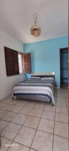 a bedroom with a bed in a blue wall at Casa bougainville in Caucaia