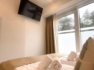 ein Schlafzimmer mit einem Bett mit einem großen Fenster in der Unterkunft Haus Nordseebrandung FeWo 3 in Cuxhaven